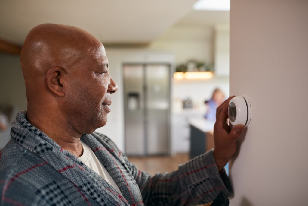 Man changing the temperature on the thermostat